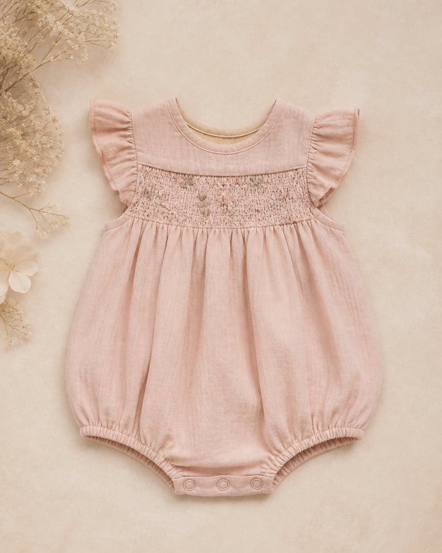 Blush heirloom romper with flutter sleeves and smocked bodice